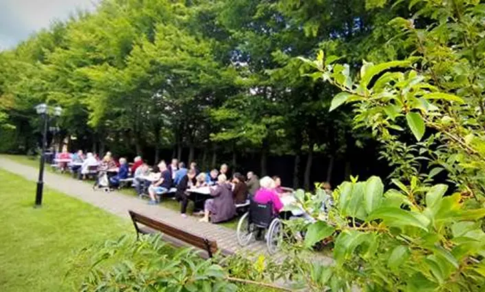 Mieszkańcy DPS ul. Kaletnicza podczas grilla w ogrodzie.